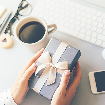 hands holding gift at desk